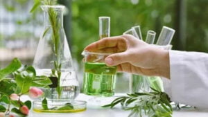 Scientist conducting plant-based research with green liquid in beakers and test tubes representing class 9 Science