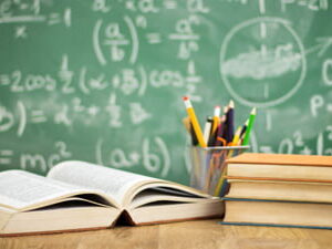 Books and pencils in front of a chalkboard with science formulas, representing Class 10 Science preparation